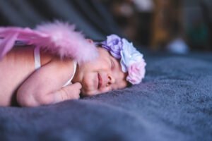 Photo de naissance bébé ange souriant accouchement Alivecom graphiste Douai lille arras